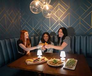 Friends making a toast in a booth 