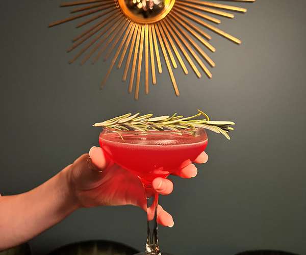 Feastive cocktail with rosemary garnish